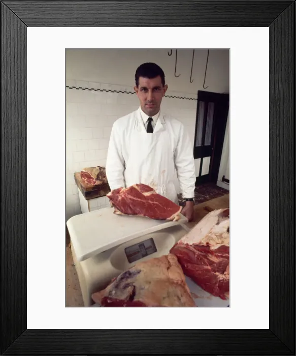 Framed Print : English referee jack Taylor weighing a joint of meat in his job as a butcher May