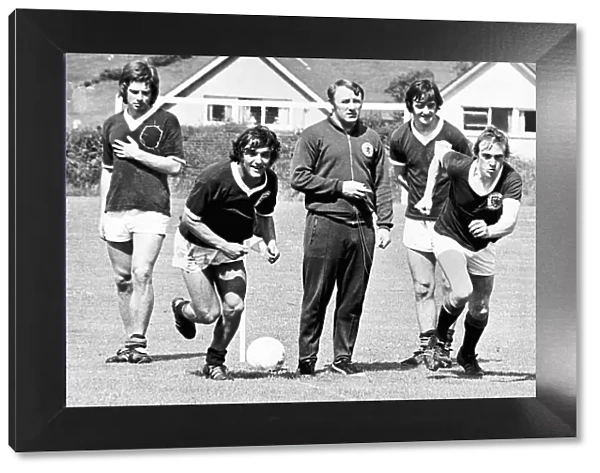 Scottish footballers Lou Macari and Colin Stein race each other as team boss Tommy