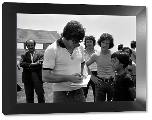England footballer Malcolm MacDonald signs autographs for young fans in training before