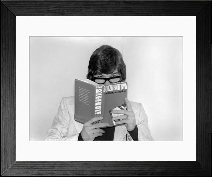 Framed Print : England footballer Malcolm MacDonald clowns around with glasses whilst reading