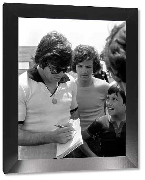 England footballer Malcolm MacDonald signs autographs for young fans in training before