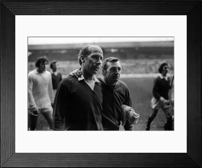 Framed Print : Bobby Charlton gets a pat on back from Leeds trainer after Leeds had beaten Manchester Framed Print : Bobby Charlton gets a pat on back from Leeds trainer after Leeds had beaten Manchester