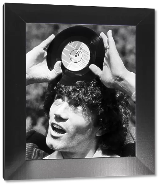 Footballer Kevin Keegan with the record he has cut called Head over Heels in Love