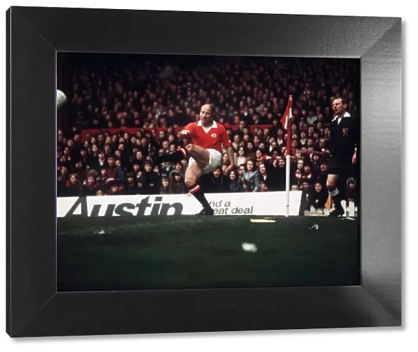 Manchester United footballer Bobby Charlton takes a corner during his last game at Old