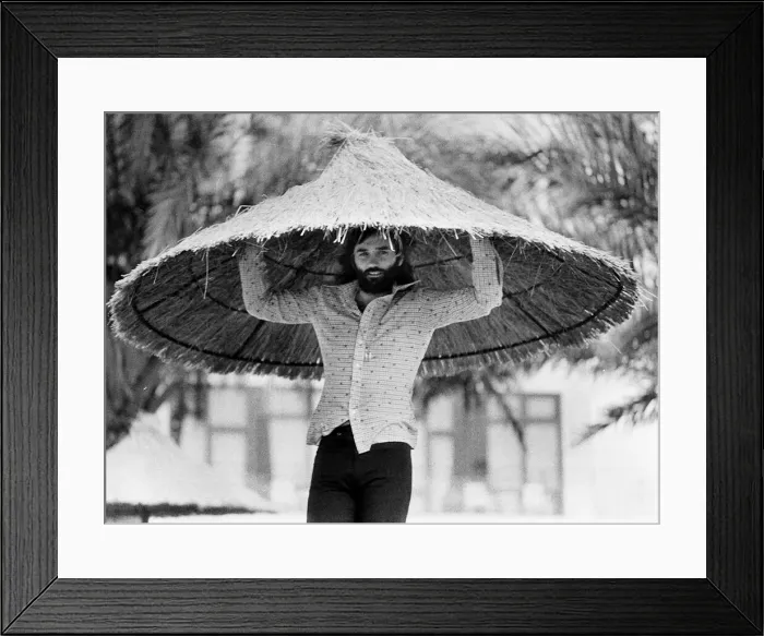 Framed Print : George Best with a over sized straw hat Circa 1974