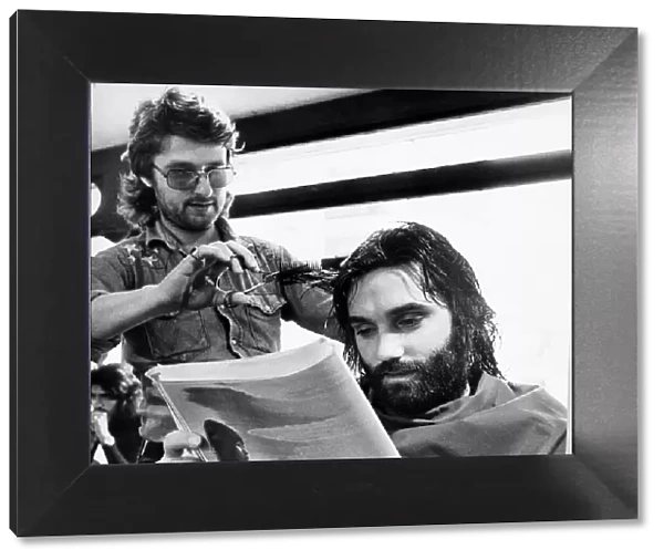 George Bests reads the paper whilst having his haircut May 1974