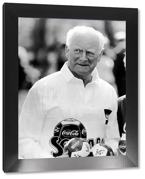 Legendary English footballer Tom Finney OBE holding a collection of Coca Cola footballs