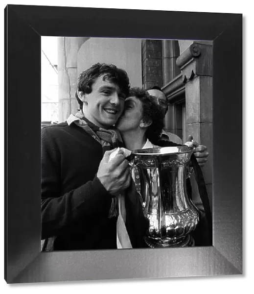 Teenager Paul Allen holds the FA Cup as his mother gives him a kiss on the cheek at