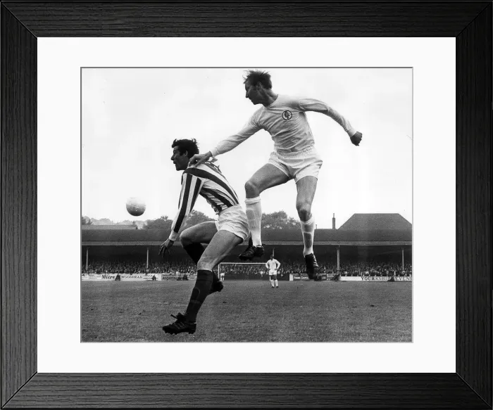 Framed Print : Jack Charlton of Leeds United jumps up to beat John Ritchie during their league match