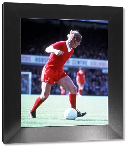 Liverpool FC footballer Kenny Dalglish running and dribbling with the ball Circa