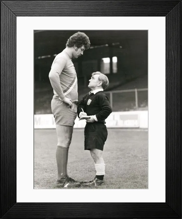 Framed Print : Pocket-sized referee telling off a tall footballer at Reading in Berkshire. February 1980 Framed Print : Pocket-sized referee telling off a tall footballer at Reading in Berkshire. February 1980