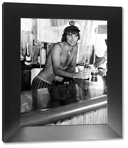 George Best Footballer in a sailors cap behind the bar in his favourite pub in Palma Nora