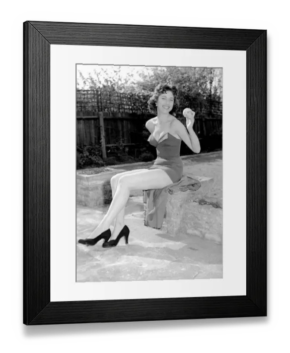 Framed Print : Woman wearing one piece swimsuit holding apple. Circa 1960 Framed Print : Woman wearing one piece swimsuit holding apple. Circa 1960