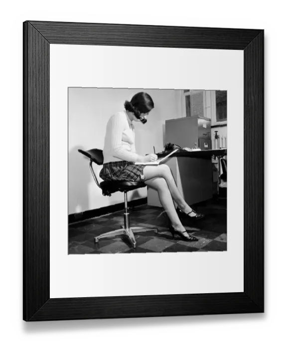 Framed Print : Reveille Studio Model posing as a secretary with a garter watch strapped to her thigh