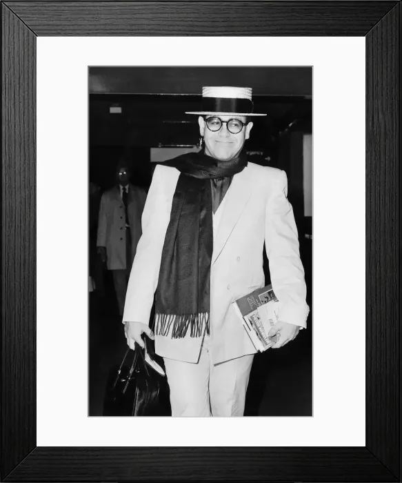 Framed Print : Elton John pop star strolls through the airport on his way to a Californian holiday Framed Print : Elton John pop star strolls through the airport on his way to a Californian holiday