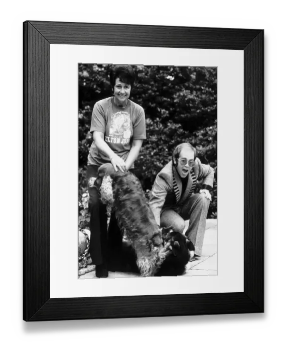 Framed Print : Elton john the singer with woman and two dogs on patio Framed Print : Elton john the singer with woman and two dogs on patio