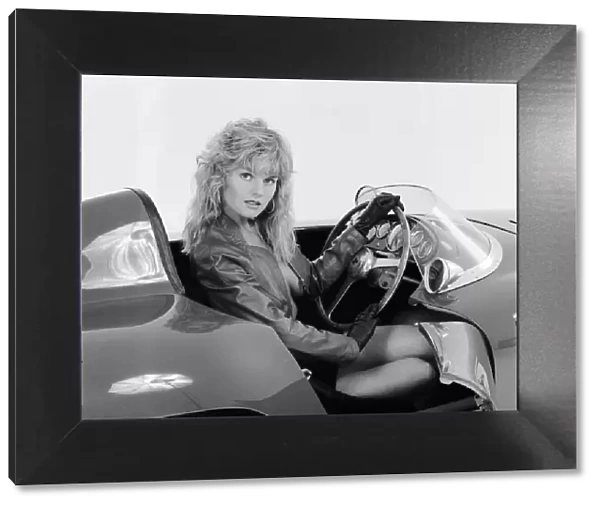 Glamour model Caroline Delahunty poses sitting in the drivers seat of a Ferrari