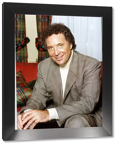Tom Jones British singer Sitting on a red couch