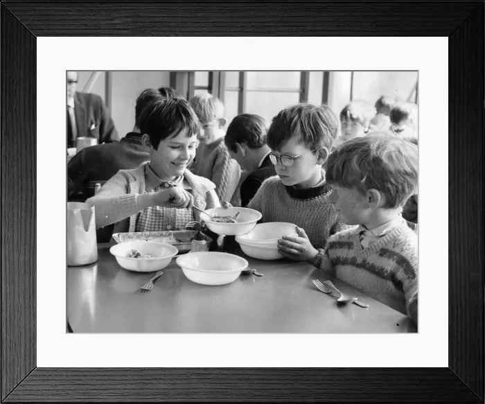 Framed Print : Big sister Christine Howarth, aged 10 dished up pudding to brother Jim, 9