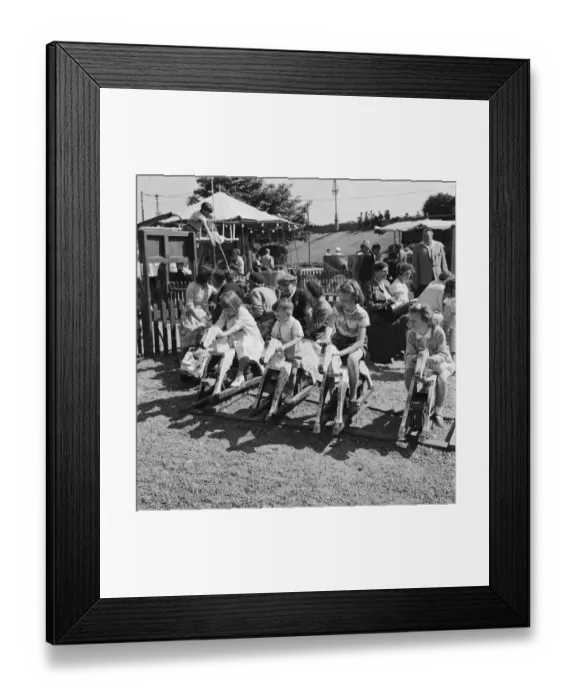 Framed Print : Boys and girls playing on the rocking horses at a childrens playground in Southend