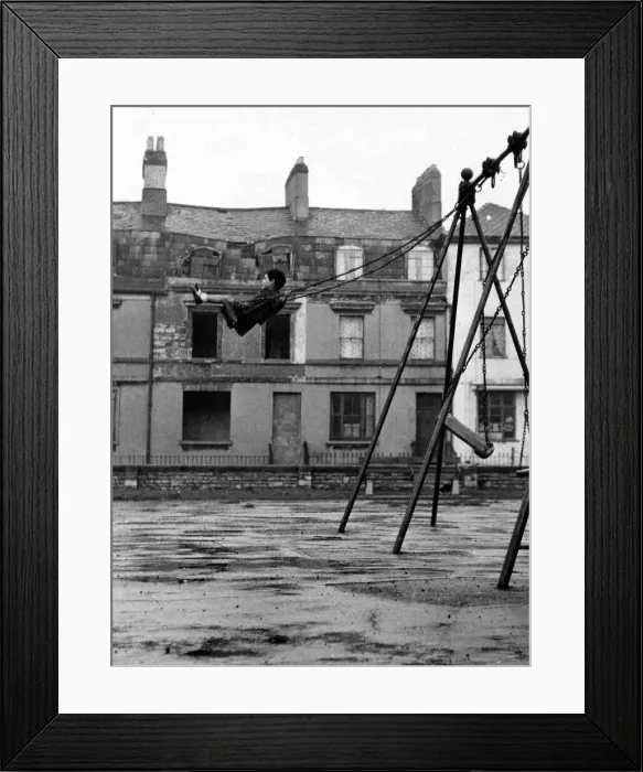 Framed Print : A youngster enjoys the swing in a playground in the docks of Butetown in Cardiff Framed Print : A youngster enjoys the swing in a playground in the docks of Butetown in Cardiff