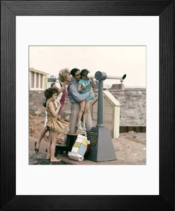 Framed Print : A family at the seaside, loking through a telescope out to sea from the shore Framed Print : A family at the seaside, loking through a telescope out to sea from the shore