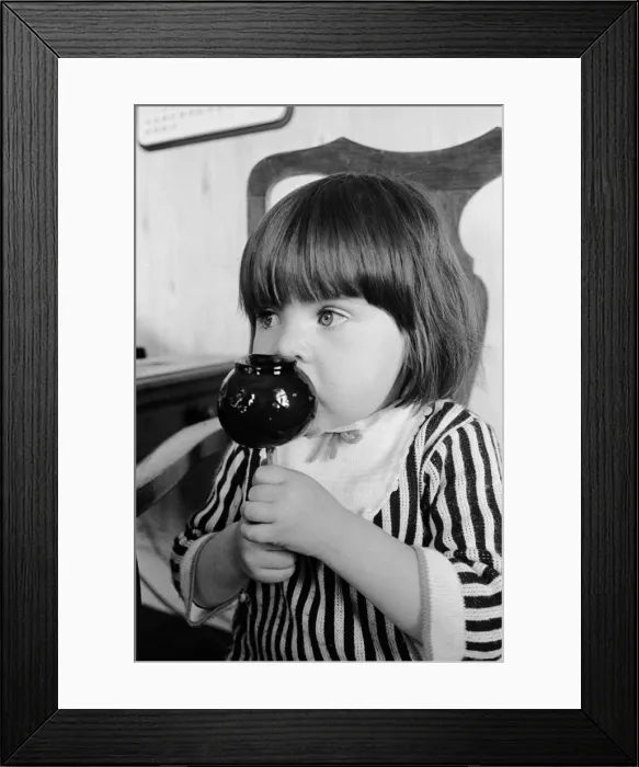 Framed Print : Two year old Tracey Emmanuel of Wembley, London, samples an old English toffee apple Framed Print : Two year old Tracey Emmanuel of Wembley, London, samples an old English toffee apple