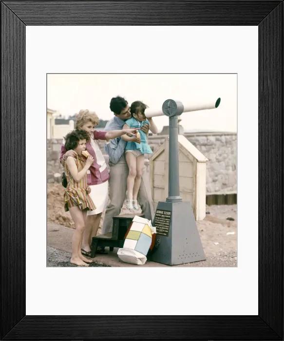 Framed Print : A family at the seaside, loking through a telescope out to sea from the shore Framed Print : A family at the seaside, loking through a telescope out to sea from the shore
