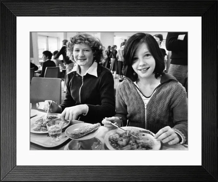 Framed Print : 13 year old Helen Boldre and Gillian Cook tuck into their school dinners