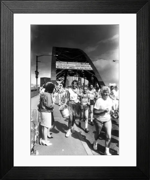 Framed Print : The Great North Run 24 July 1988 - One of the runners collecting for charity carrying her Framed Print : The Great North Run 24 July 1988 - One of the runners collecting for charity carrying her