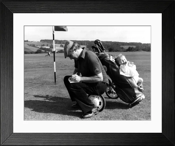 Framed Print : Golf fanatic David Moore who adapted his golf trolley to accomodate his baby daughter Framed Print : Golf fanatic David Moore who adapted his golf trolley to accomodate his baby daughter