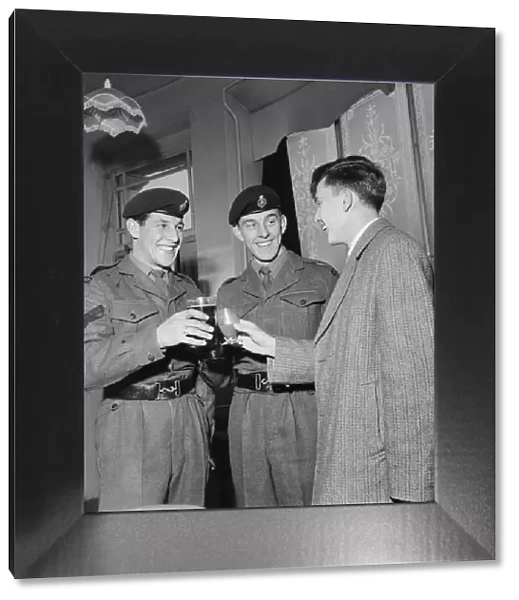 British pop singer Terry Dene (right) enjoys a drink with Corporal B Goodall (left