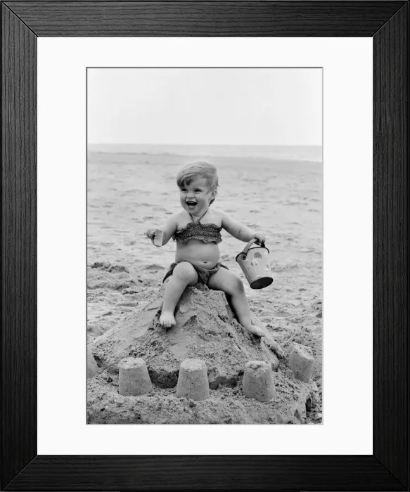 Framed Print : Seventeen month old Sarah Jukes from Wimbledon plays in the sand during a day