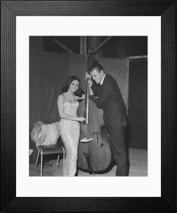 Framed Print : Pop singer Susan Maughan and actor Roger Moore photographed with a cello backstage during