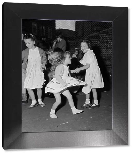 Children dancing to rock n roll music at a block of flats off Chapel Market