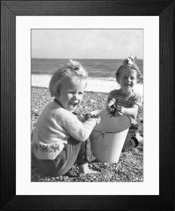 Framed Print : Sally Power 5 & her younger sister Rosemary Power, pictured playing on the pebble beach Framed Print : Sally Power 5 & her younger sister Rosemary Power, pictured playing on the pebble beach