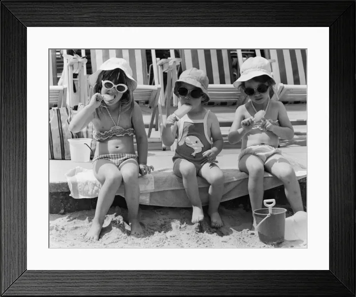 Framed Print : Three young girls sitting on the beach, enjoying an ice lolly. 26th June 1979 Framed Print : Three young girls sitting on the beach, enjoying an ice lolly. 26th June 1979