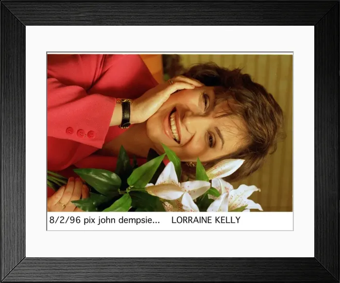 Framed Print : Lorraine KELLY next to a green white plant red jacket watch