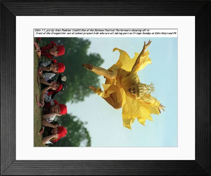 Framed Print : A festival performer dressed as a cruel yellow fairy leaps over the Craigmiller out of Framed Print : A festival performer dressed as a cruel yellow fairy leaps over the Craigmiller out of