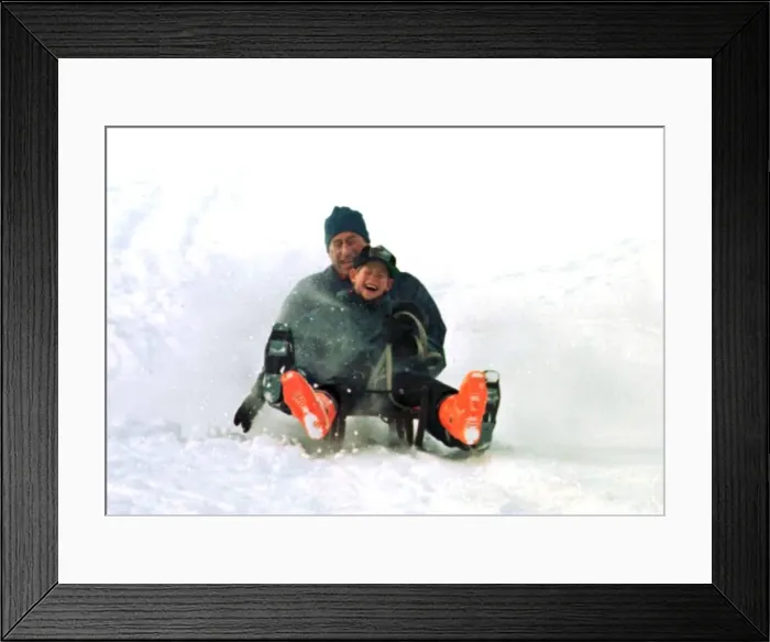 Framed Print : Prince Charles on a sledge with Prince Harry while on holiday in Klosters Framed Print : Prince Charles on a sledge with Prince Harry while on holiday in Klosters
