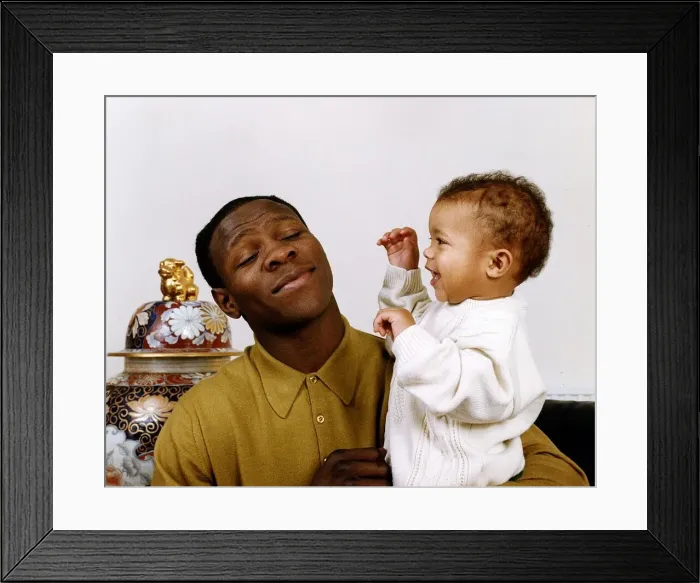 Framed Print : Chris Eubank boxer holding his baby in his arms Framed Print : Chris Eubank boxer holding his baby in his arms