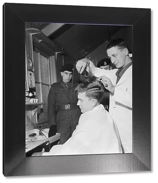 British pop singer Terry Dene gets a haircut from Rifleman G P Pennycook at Winchester