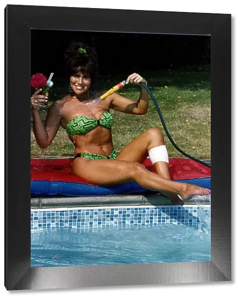 Linda Lusardi Model  /  TV Presenter sitting by poolside spraying water on to her chest