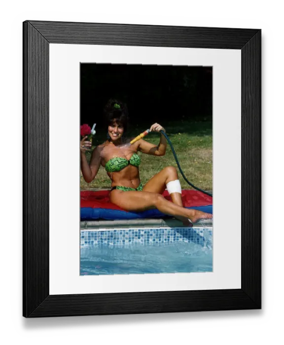 Framed Print : Linda Lusardi Model / TV Presenter sitting by poolside spraying water on to her chest Framed Print : Linda Lusardi Model / TV Presenter sitting by poolside spraying water on to her chest