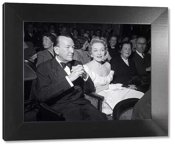 Marlene Dietrich sitting in the stalls of the Globe Theatre with Noel Coward whose play