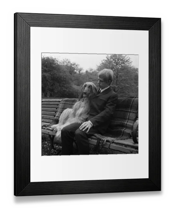 Framed Print : Man and dog sitting on park bench circa 1970
