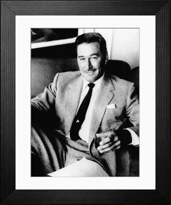 Framed Print : Errol Flynn Actor- September 1977 sitting in a chair with a glass in his Framed Print : Errol Flynn Actor- September 1977 sitting in a chair with a glass in his
