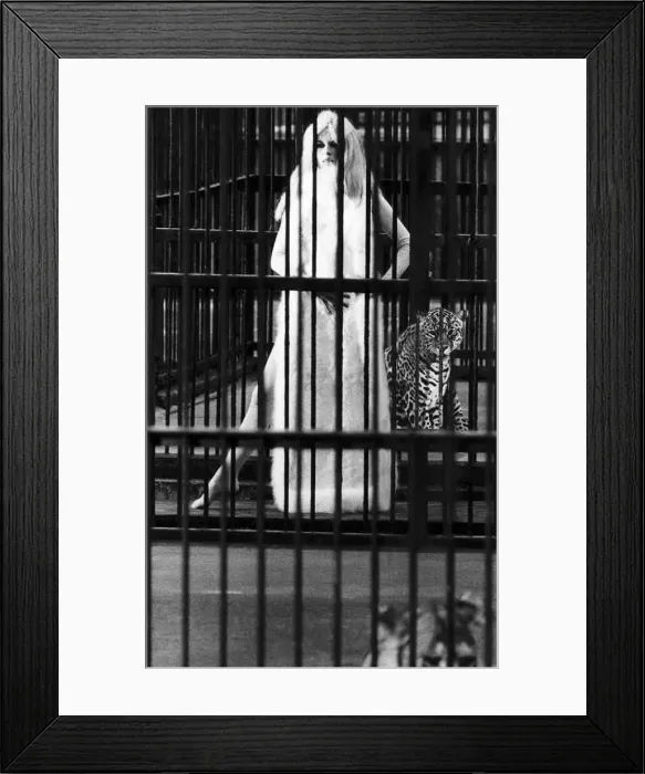 : Brigitte Bardot French actress in skin tight catsuit with fur cape standing beside cage : Brigitte Bardot French actress in skin tight catsuit with fur cape standing beside cage