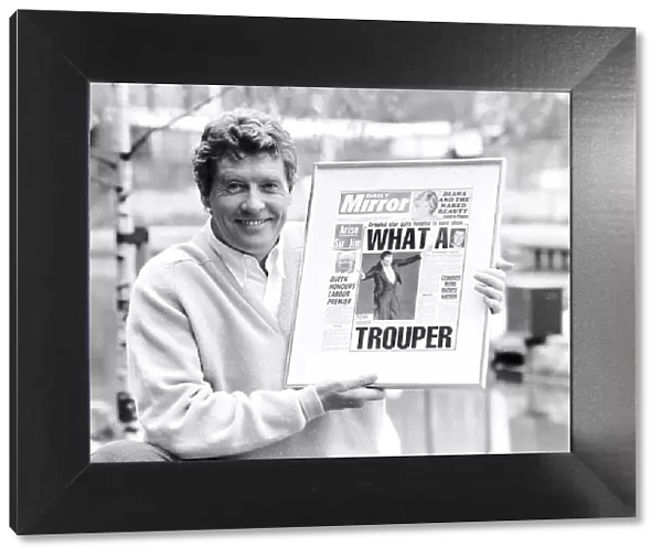 Michael Crawford holds up a framed front page of the Daily Mirror June 1987