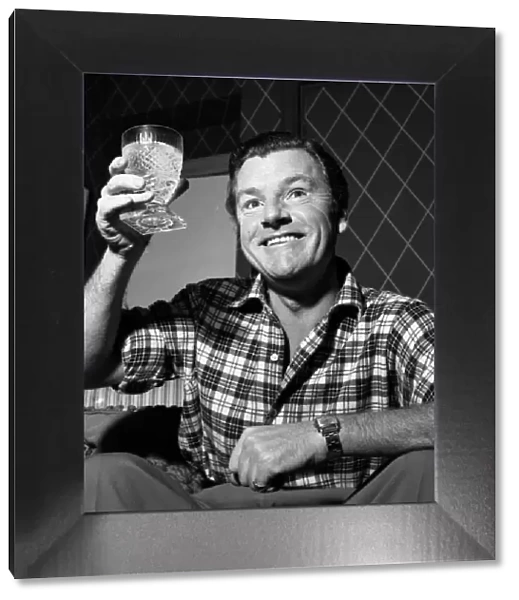 Actor Kenneth More raises his glass before having a drink December 1956